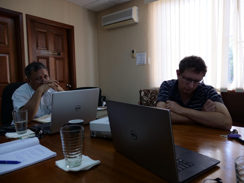 Lobster fishery staff sit at a desk with their computers during a Skype interview.